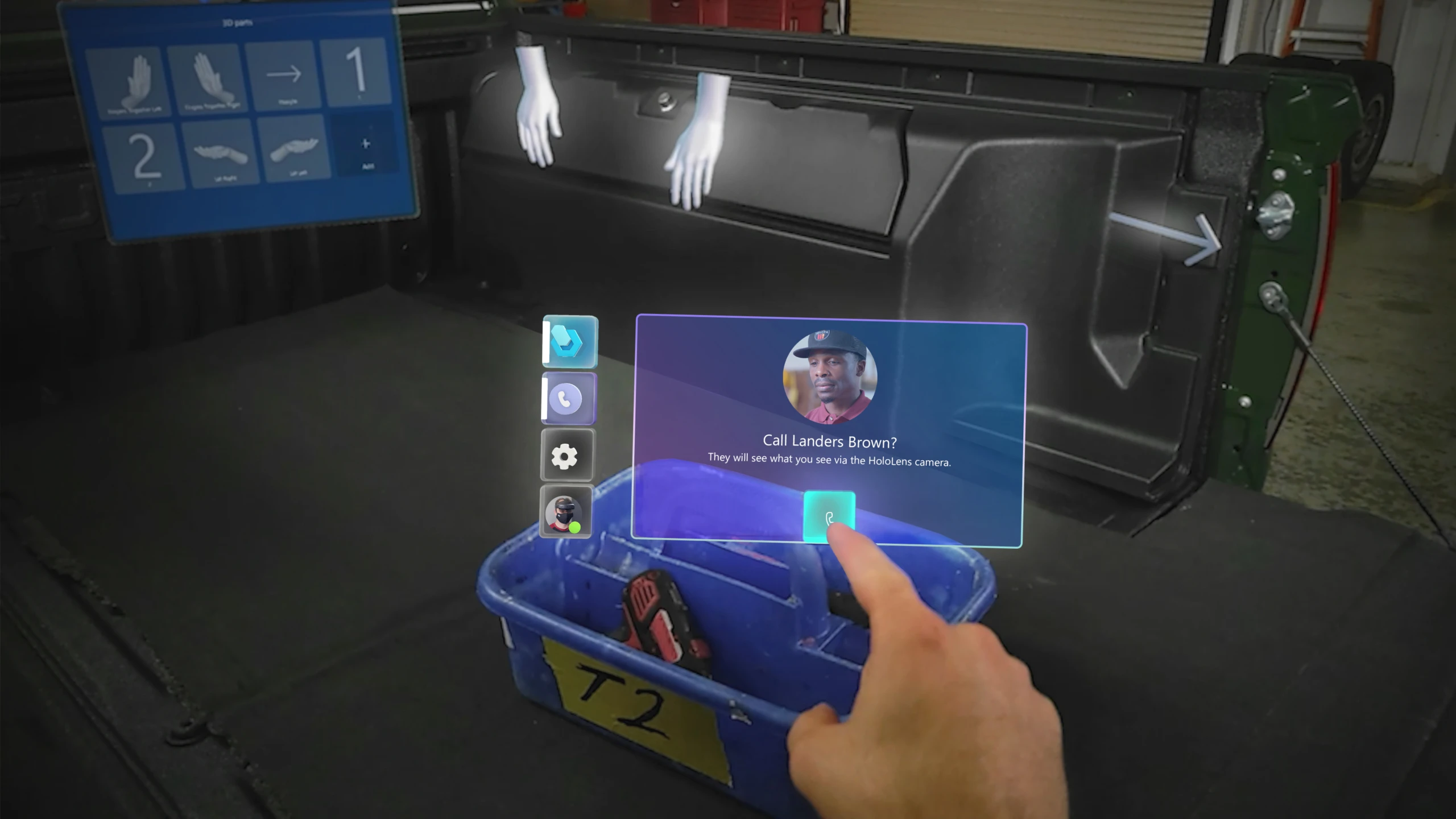 A user's mixed reality view from their HoloLens, showing their hand using touch controls for starting a holographic video call with a remote colleague.
