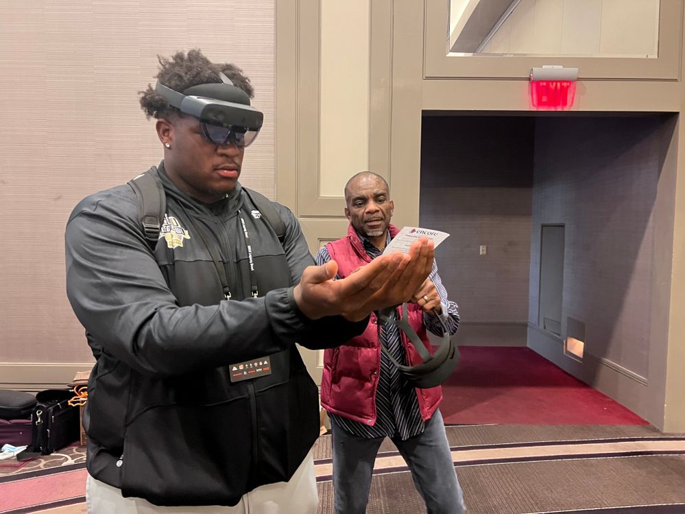 Ezra Jay demoing a HoloLens 2 with a student.