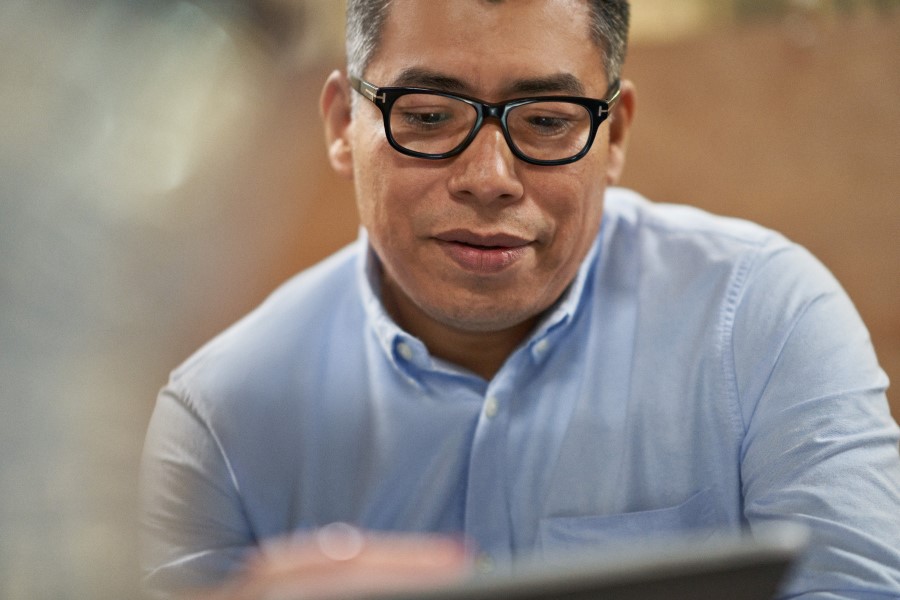 Close-up of a man looking down at a screen.