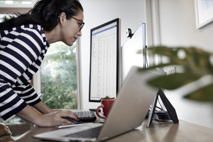 a person sitting at a table using a laptop computer